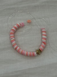 a pink and white bead bracelet on a white surface